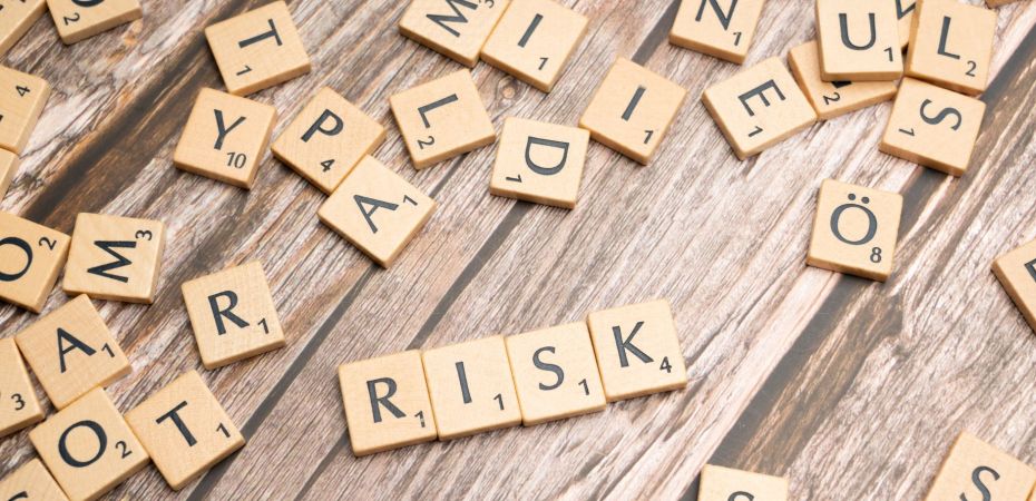 scrabble letters spelling risk on a wooden table