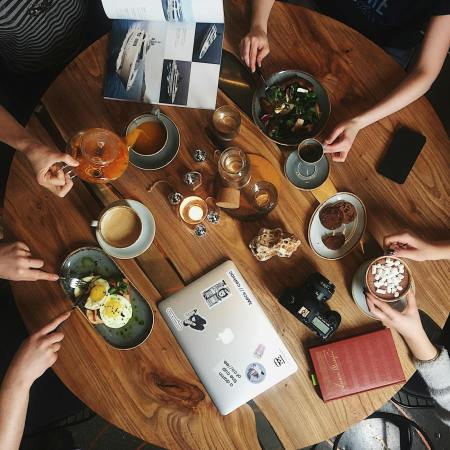 people holding cups and mugs by table